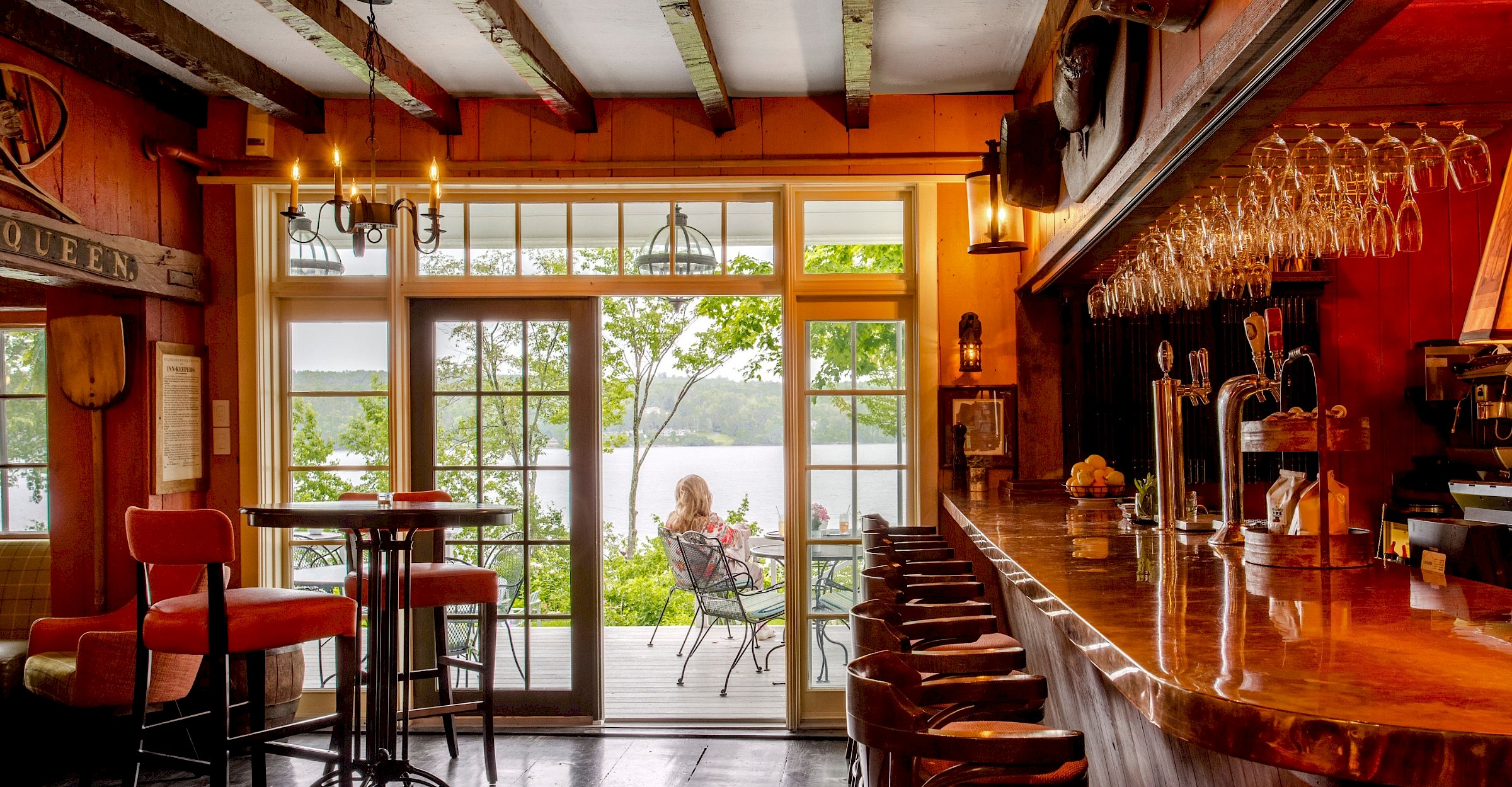 Vue sur le bistro avec un bar, des tables et une terrace qui donne sur le lac