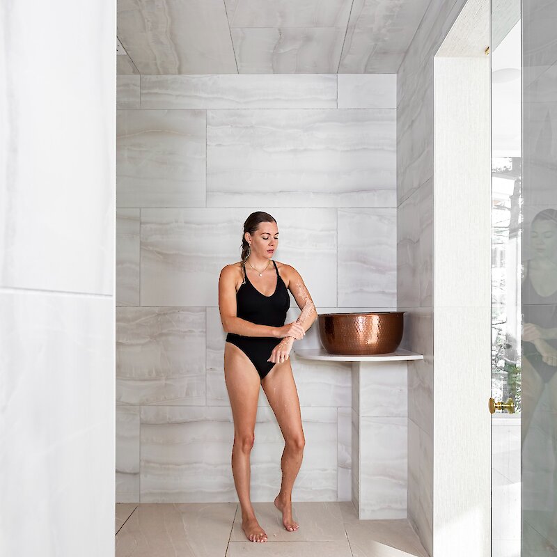 A woman taking a shower at the spa