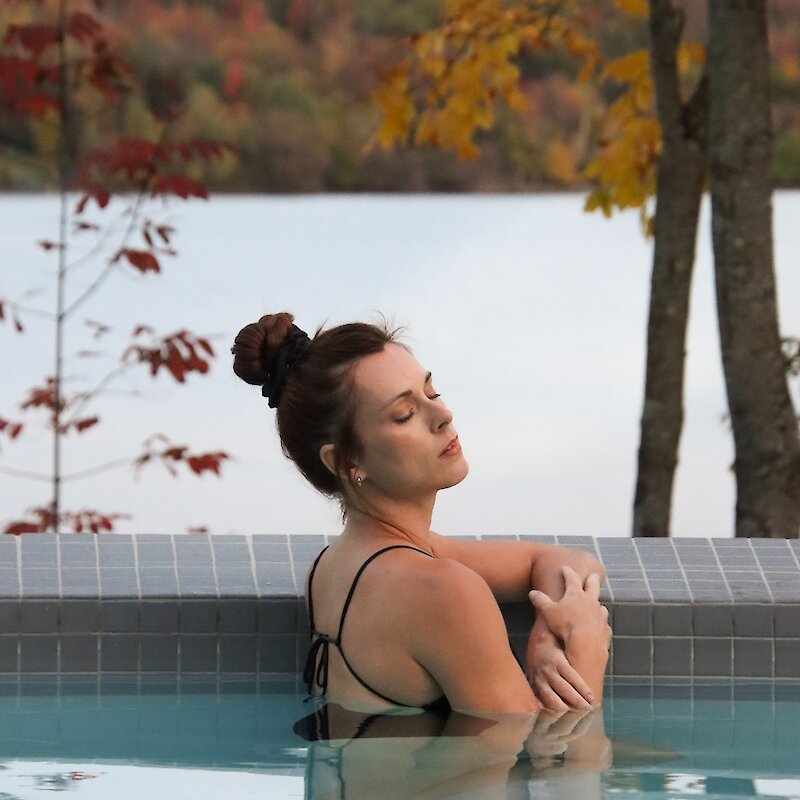 Une femme se repose au bord d'une piscine.
